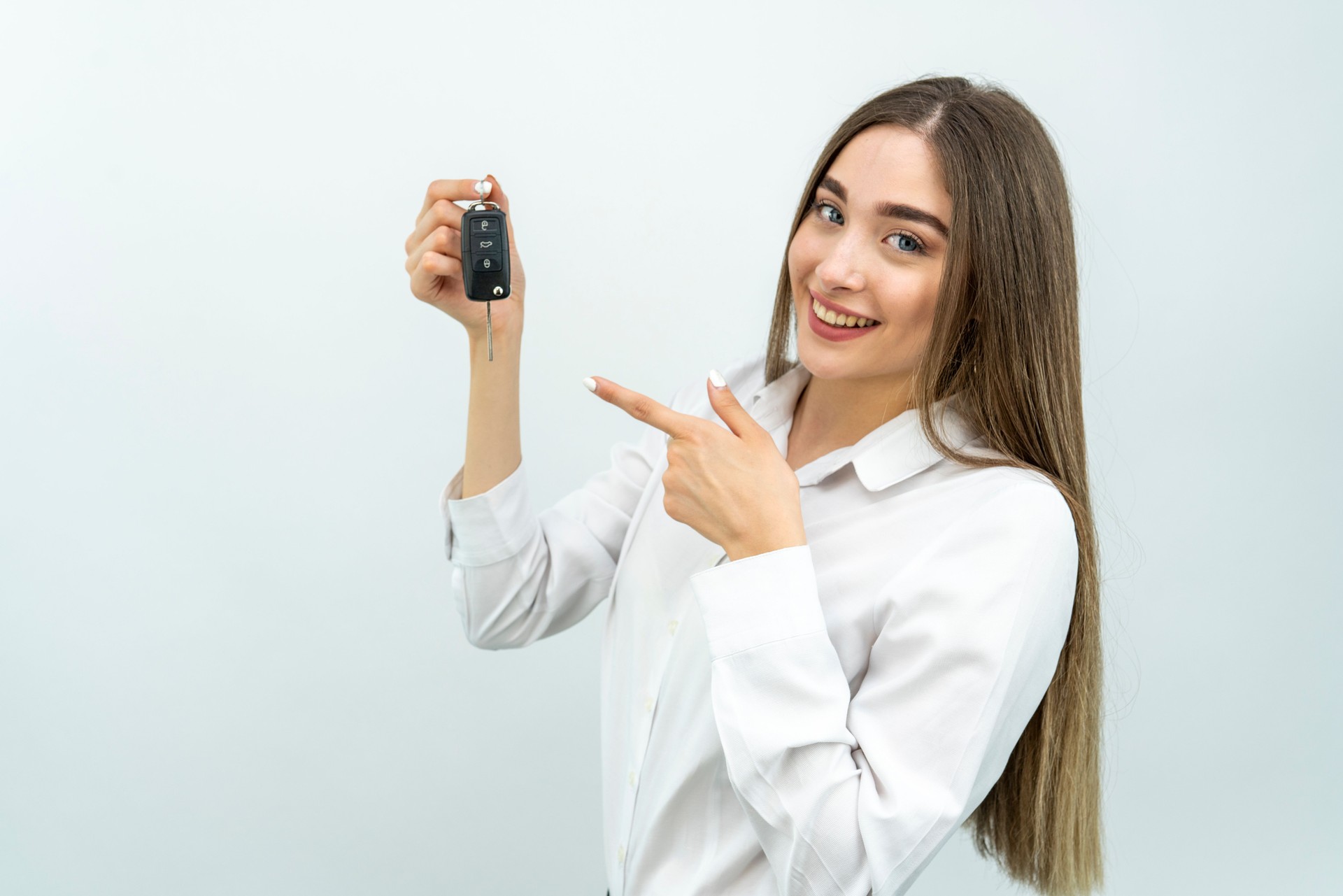 Woman with a car keys. Isolated on white background.
